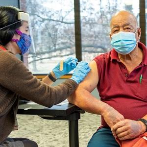 Arkansas CEAL man in red shirt getting vaccinated