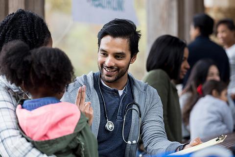 Young doctor interacting with a woman and child